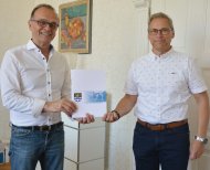 Landrat Dr. Fritz Brechtel (links) gratuliert Bernd Schwager, Hausmeister der Geschwister-Scholl-Realschule-Plus in Germersheim, zu dessen 25-jährigem Dienstjubiläum. (Foto: Kreisverwaltung Germersheim, Michael d’Aguiar)