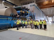 Werkleiter Jürgen Kosse mit den Teilnehmenden der Betriebserkundungs-Tournee an der Papiermaschine PM. Foto: KVGER