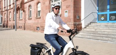 Auch Landrat Martin Brandl hat es sich nicht nehmen lassen mit dem E-Bike für die Teilnahme zu werben und hat bei strahlendem Sonnenschein heute einige Runden vor dem Kreishaus in Germersheim gedreht.