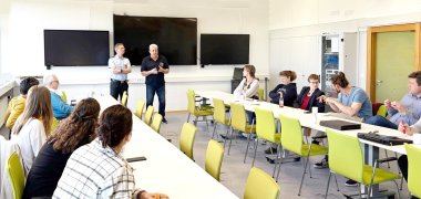 Brand- und Katastrophenschutzinspekteur Christian Betzel (stehend in Uniform) und daneben Schulungsleiter Mathias Deubig während der Verwaltungsstab-Schulung im Führungs- und Lagezentrum in Bellheim.