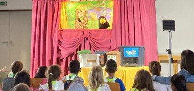Die Puppen stellen wichtige Themen einfach dar. das foto zeigt Die Puppen und die begeisterten kinder.