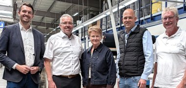 Das Foto (KreisGER / Farrenkopf) zeigt (v.l.n.r.) Tim Wiedemann, Hauptgeschäftsführer der IHK Pfalz, Klaus Ade, Geschäftsführer der SKA Sitze GmbH, Kreisbeigeordnete Anette Kloos mit Landrat Martin Brandl und dem Ortsvorsteher von Wörth, Helmut Wesper.