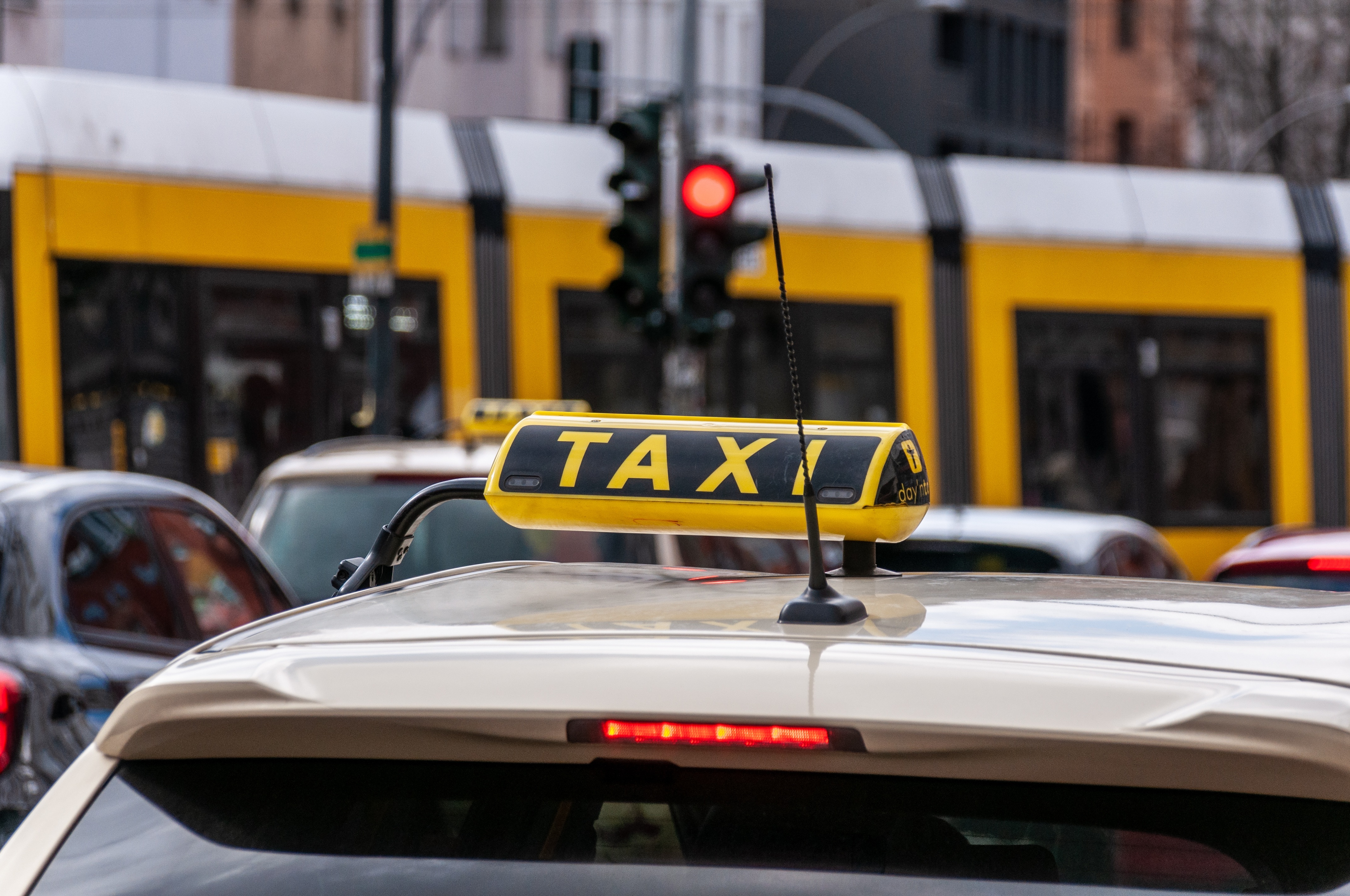 taxibil mit taxischild im vordergrund.