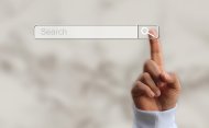 foto eines fingerzeigs über ein Suchfeld im Web