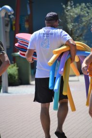 Eine person hält schwimmnudeln unterm arm.
