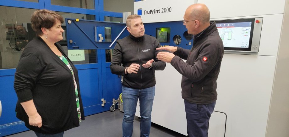 Beeindruckt zeigen sich Kreisbeigeordnete Anette Kloos, Bürgermeister Karl-Dieter Wünstel und Wirtschaftsförderin Maria Farrenkopf von den pulverbettbasierten Laserstrahlschmelzen. Danke für diesen tollen Einblick.